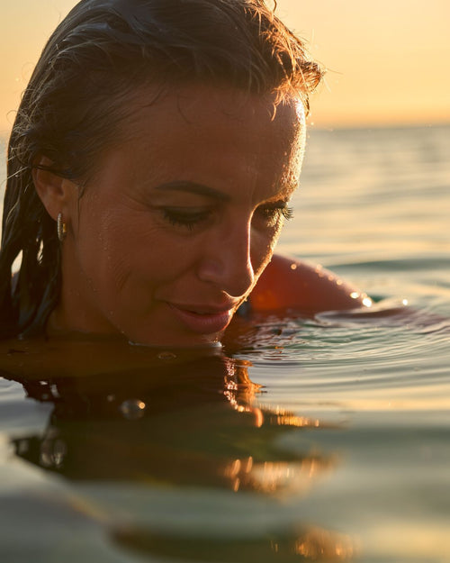 Portrait of a woman in the sea at dawn, reflecting courage, self-reclamation, and rebuilding identity after a long-term relationship.